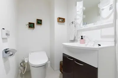 a white bathroom with a toilet and a sink at Asakusa Sky Stay Tiffany blue Room in Tokyo
