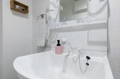 a white bathroom with a sink and a mirror at Asakusa Sky Stay Tiffany blue Room in Tokyo