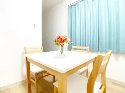 a dining room table with a vase of flowers on it at Sunstay - Higashi-Nakano in Tokyo