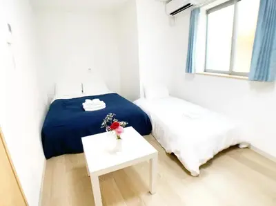 a small bedroom with a bed and a table at Sunstay - Higashi-Nakano in Tokyo