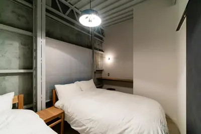 a bedroom with two beds and a light on the wall at prosperityta Yutaka 2F / Vacation STAY 80031 in Tokyo