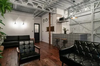 a living room with black leather furniture and a kitchen at prosperityta Yutaka 2F / Vacation STAY 80031 in Tokyo
