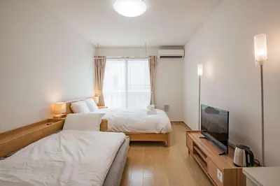 a bedroom with two beds and a flat screen tv at Noah Ikebukuro / Vacation STAY 7298 in Tokyo