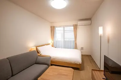 a bedroom with a bed and a couch and a window at Noah Ikebukuro / Vacation STAY 7295 in Tokyo