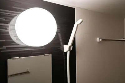 a bathroom with a mirror and a light on the wall at Noah Ikebukuro / Vacation STAY 7294 in Tokyo