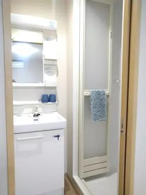 a kitchen with a white refrigerator and a sink at Issyuku Higashiueno Hotel in Tokyo
