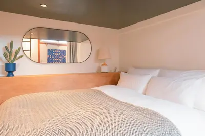 a bedroom with a white bed and a mirror at illi Esu Nakano in Tokyo