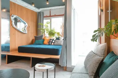 a living room with a blue couch and a window at illi Esu Nakano in Tokyo