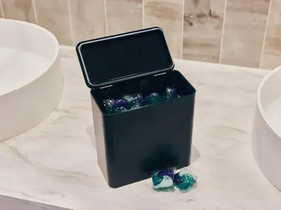 a black container sitting on top of a counter with two shoes at illi Esu Nakano in Tokyo