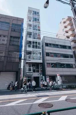 a group of people walking on a city street with buildings at illi Esu Nakano in Tokyo