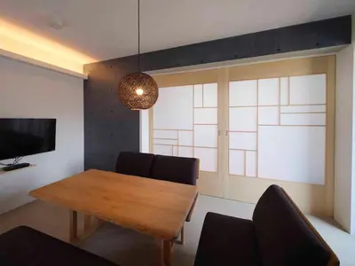 a dining room with a wooden table and a television at East SQUARE Tokyo in Tokyo