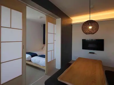 a bedroom with a bed and a table and a television at East SQUARE Tokyo in Tokyo