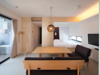 a living room with a table and a bedroom at East SQUARE Tokyo in Tokyo