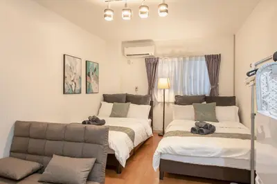 a living room with two beds and a couch at Asakusa Panda Hostel in Tokyo