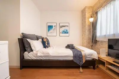 a bedroom with a bed and a television in it at Asakusa Panda Hostel in Tokyo
