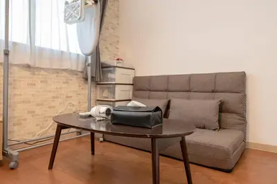 a living room with a couch and a table with a purse on it at Asakusa Panda Hostel in Tokyo