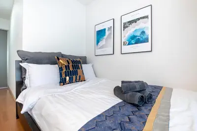 a bedroom with a white bed with a blue rug at Asakusa Panda Hostel in Tokyo