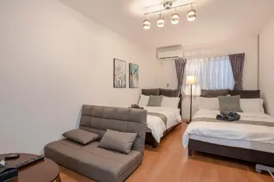 a living room with two beds and a couch at Asakusa Panda Hostel in Tokyo