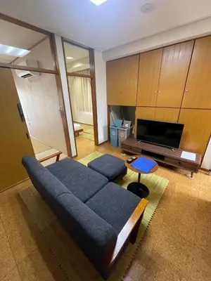 a living room with a blue couch and a flat screen tv at \u30a2\u30f3\u30c9\u30b9\u30c6\u30a4\u662d\u548c\u753a in Tokyo
