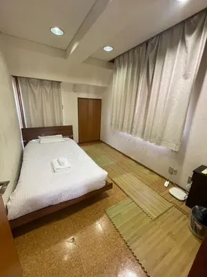 a bedroom with a bed and a large window at \u30a2\u30f3\u30c9\u30b9\u30c6\u30a4\u662d\u548c\u753a in Tokyo