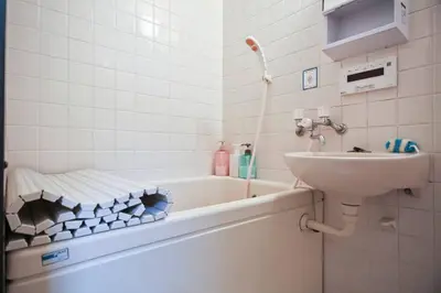 a bathroom with a sink and a bath tub with a sink at \u30a2\u30f3\u30c9\u30b9\u30c6\u30a4\u662d\u548c\u753a in Tokyo