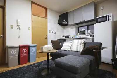 a living room with a couch and a kitchen at \u30a2\u30f3\u30c9\u30b9\u30c6\u30a4\u662d\u548c\u753a in Tokyo