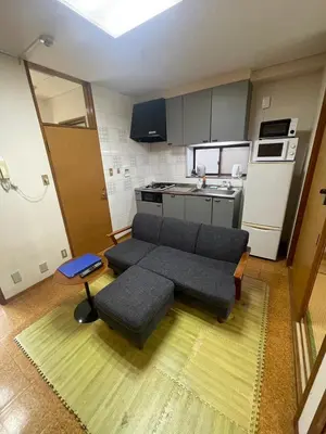 a living room with a couch and a kitchen at \u30a2\u30f3\u30c9\u30b9\u30c6\u30a4\u662d\u548c\u753a in Tokyo