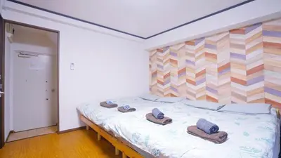 a bedroom with a bed with towels and slippers on it at TOKYO ICHIBAN ASAKUSA in Tokyo