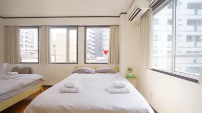two beds in a room with two windows at TOKYO ICHIBAN ASAKUSA in Tokyo