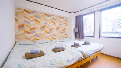 a bedroom with a large bed with three hats on it at TOKYO ICHIBAN ASAKUSA in Tokyo
