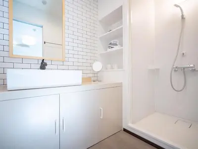 a white bathroom with a sink and a shower at Tsubame Hotel Asakusabashi 3 minutes walk from Asakusabashi Station Near Asakusa, Akihabara, and Ueno Cooking utensils and kitchen washing machine available Direct access to Haneda and Narita airports in Tokyo