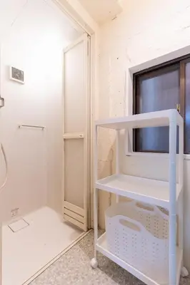 a bathroom with white shelves and a window at LUANAHOTEL IN NAKANO in Tokyo
