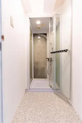 a shower with a glass door in a bathroom at LUANAHOTEL IN NAKANO in Tokyo