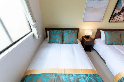 a small bedroom with two beds and a window at LUANAHOTEL IN NAKANO in Tokyo