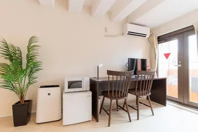 a room with a desk with a computer and chairs at LUANAHOTEL IN NAKANO in Tokyo
