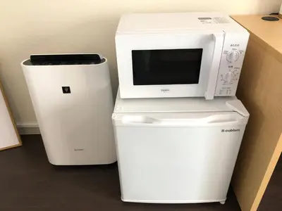 a microwave sitting on top of a water cooler at LUANAHOTEL IN NAKANO in Tokyo