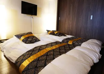 two beds in a hotel room with white sheets and pillows at Taito-ku - Apartment / Vacation STAY 80790 in Tokyo