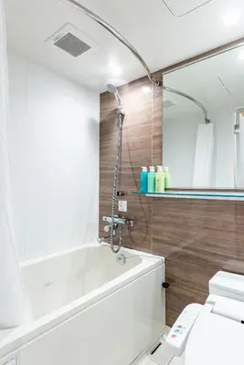 a bathroom with a shower and a white tub at Hotel Kazusaya in Tokyo