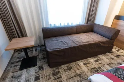 a brown couch sitting in a living room with a table at Hotel Kazusaya in Tokyo