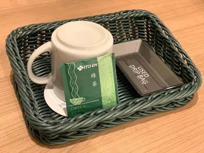 a basket with a cup of coffee and a pack of tea at Hotel Kazusaya in Tokyo