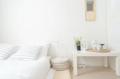 a white bedroom with a white bed and a desk at Miyako Shinjuku Hotel \u90fd-\u65b0\u5bbf- in Tokyo