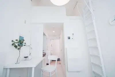a white room with a staircase and white chairs at Miyako Shinjuku Hotel \u90fd-\u65b0\u5bbf- in Tokyo