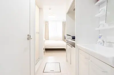 a white bathroom with a white sink and a door at Miyako Shinjuku Hotel \u90fd-\u65b0\u5bbf- in Tokyo