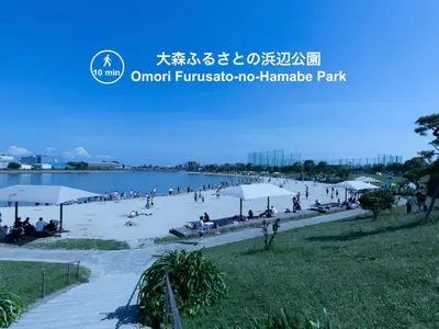 a group of people on a beach with umbrellas at Home Sweet Office Heiwajima in Tokyo