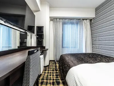 a hotel room with a bed and a window at APA Hotel Roppongi SIX in Tokyo
