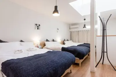 two beds in a room with white walls at \u30a2\u30f3\u30c9\u30b9\u30c6\u30a4\u6cbc\u888b in Tokyo