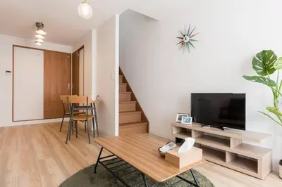 a living room with a television and a table at \u30a2\u30f3\u30c9\u30b9\u30c6\u30a4\u6cbc\u888b in Tokyo