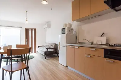a kitchen with a table and a white refrigerator at \u30a2\u30f3\u30c9\u30b9\u30c6\u30a4\u6cbc\u888b in Tokyo