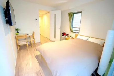 a bedroom with a large white bed and a table at Jeffery Skytree Residence Tokyo in Tokyo