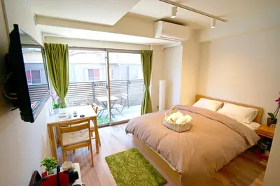 a bedroom with a bed and a desk and a balcony at Jeffery Skytree Residence Tokyo in Tokyo